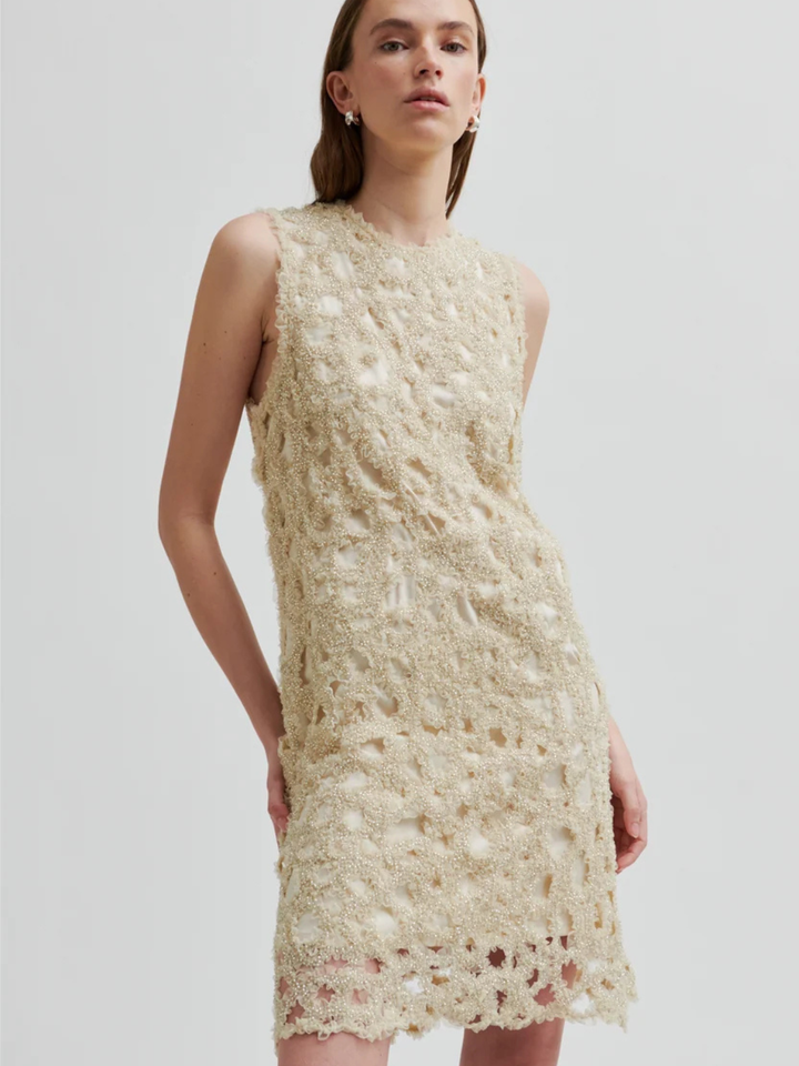 Second Female Gleam Dress i beige med dekorativt perlemønster, rund hals, ærmeløst design og let A-formet silhuet.